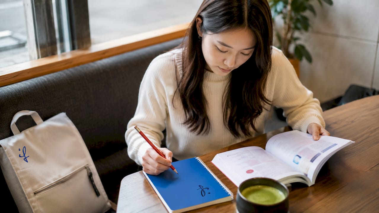 Young woman studying Japanese words at table