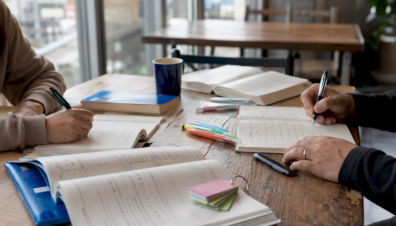 Adult learners holding Japanese language study books
