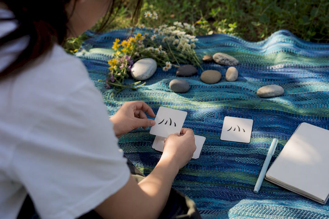 Hands tracing fire radical flashcard on tatami mat