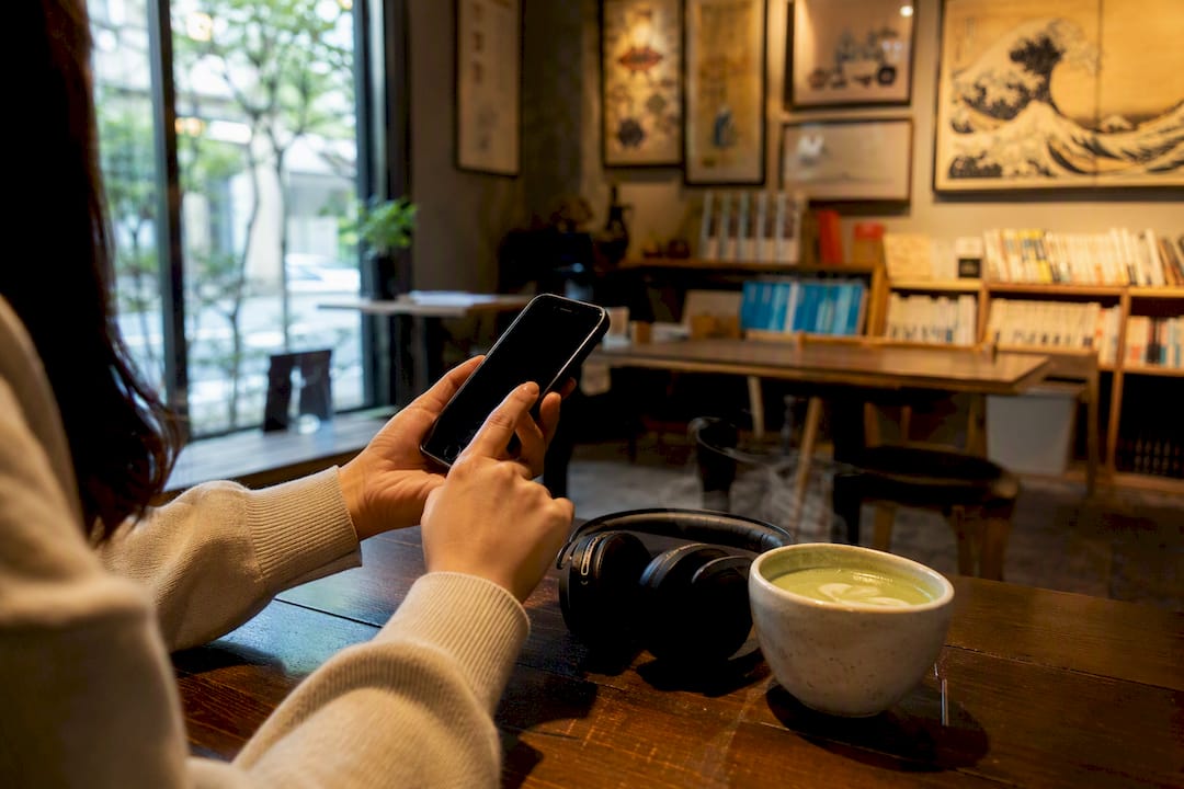 Hands adjusting audio playback for shadowing practice