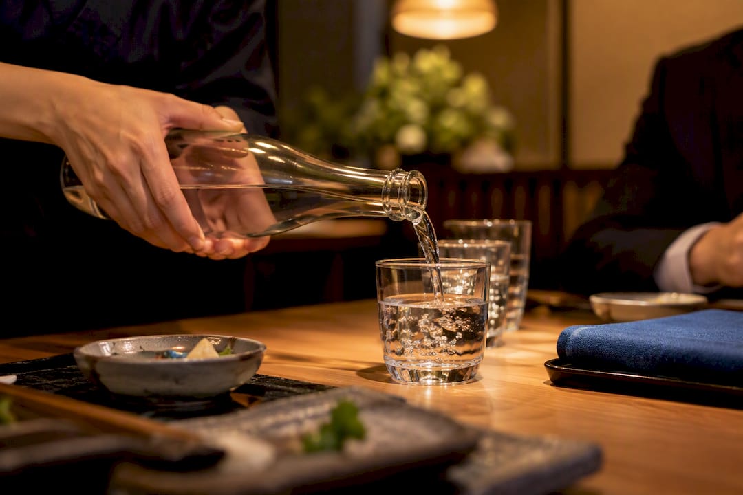 Two hands pouring water at lunch